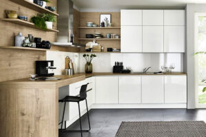 Moderne weiße Küche mit großen Holzflächen, die durch kontrastreiche Materialien für eine natürliche und warme Atmosphäre sorgt.