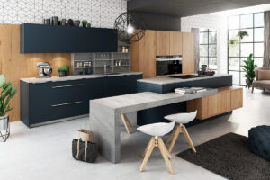 Moderne Küche mit teils Holzfronten, teils dunklen, matten blaugrauen Fronten und Akzenten in Betonoptik für einen urbanen und stilvollen Look.