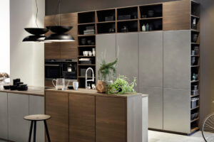 Moderne Designküche mit Edelstahlfronten und Nussbaumoptik, kombiniert mit offenen Regalen von Nolte.