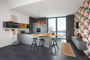 Mattgraue moderne Küche mit Kochinsel und integrierter Sitzgelegenheit – elegantes Design mit klaren Linien.