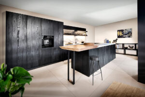 Moderne schwarze Küche aus der Wood Unlimited Serie mit edlen Holzfronten im Raw-Look – handwerklich inspiriertes Design mit individueller Note von Rotpunkt.