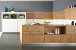 Küche mit Küchenschränken aus hellem Holz und weißen Elementen, kombiniert zu einem freundlichen und modernen Design.