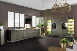 Küche mit Fronten in schwarzer Marmoroptik, heller dünner Arbeitsplatte, wandintegrierten Hochschränken mit Elektrogeräten und eleganten Milchglas-Elementen.